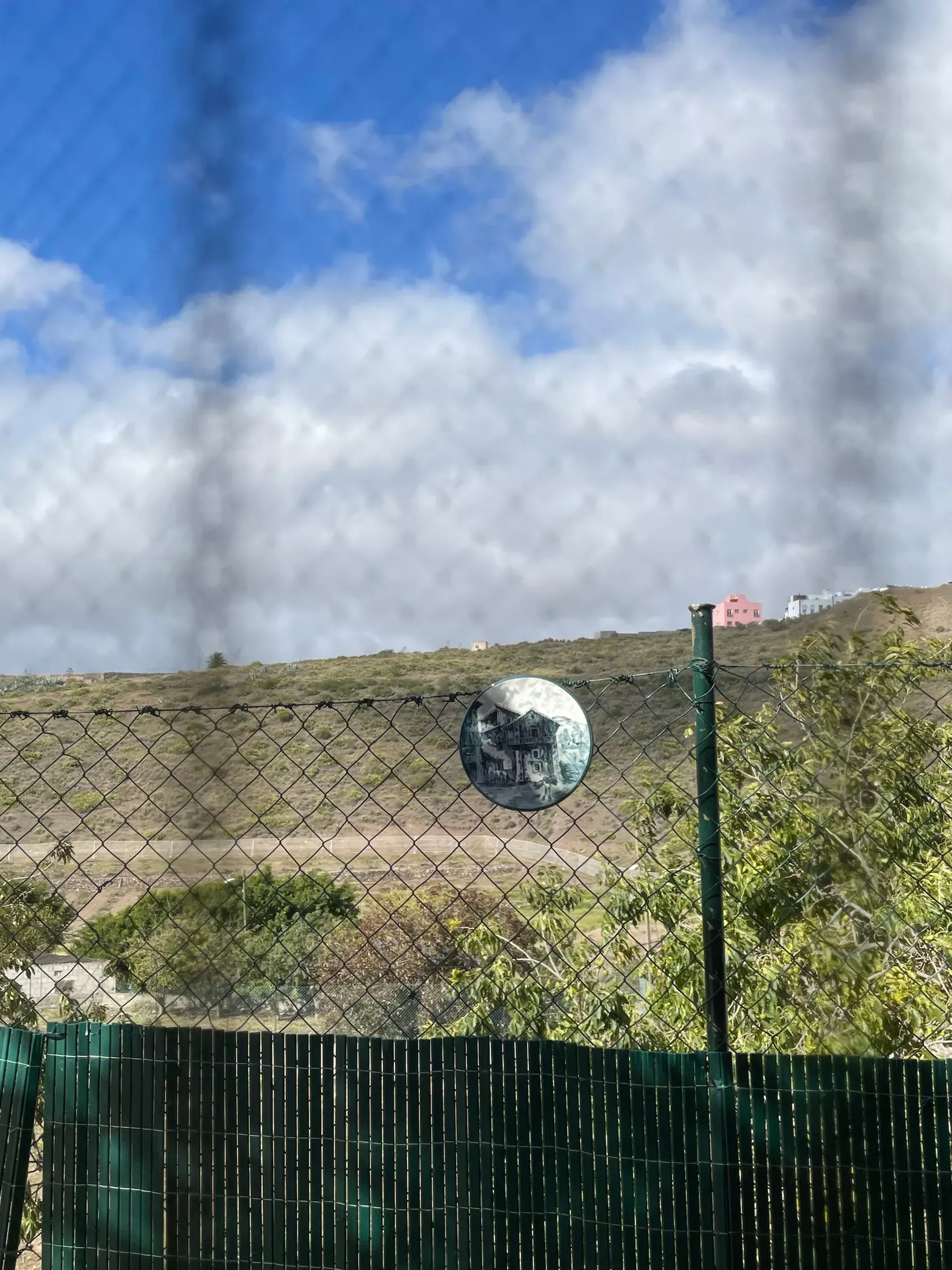 Some hills in the background and a plate hanging on a fence in Gran Canaria.