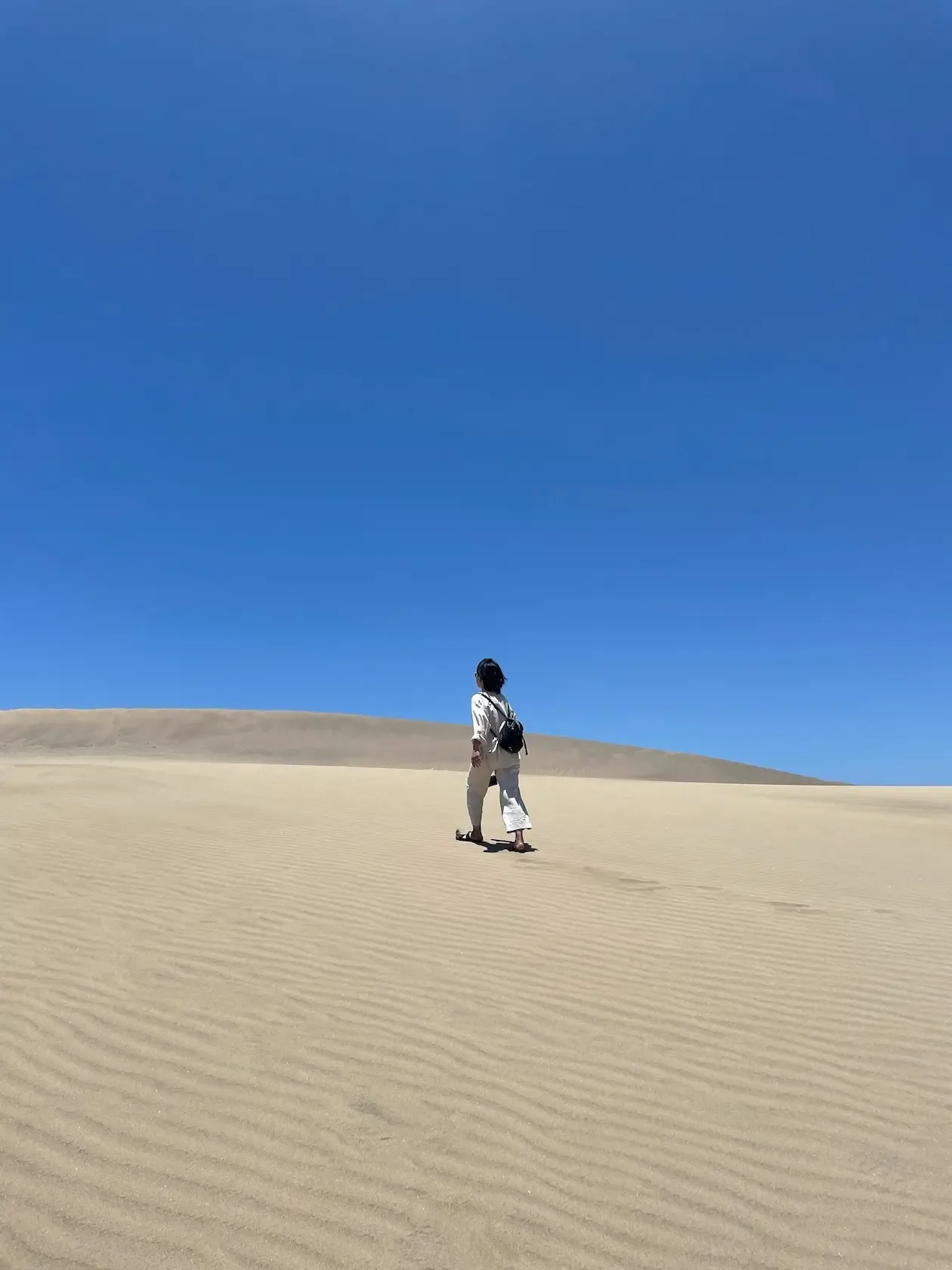 A woman walking in the sand dunes of Maspalomas, Gran Canaria.